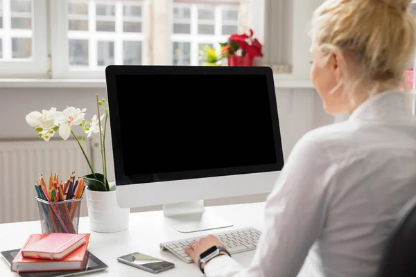 Frau im Büro arbeitet am stationären Computer — Stockfoto