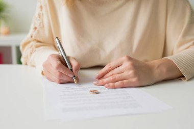 Woman going through divorce and signing papers clipart