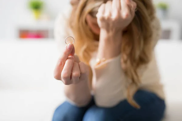 Smutná žena držící snubní prsten — Stock fotografie