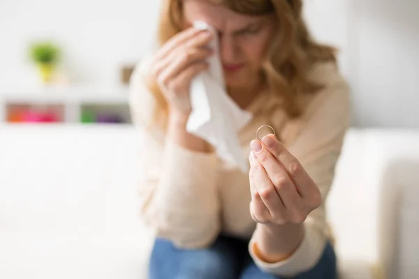 Donna che attraversa il divorzio tenendo fede alla fede nuziale e piangendo — Foto Stock