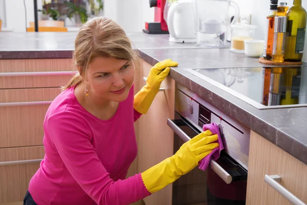 Ibu rumah tangga membersihkan kompor dapur — Stok Foto