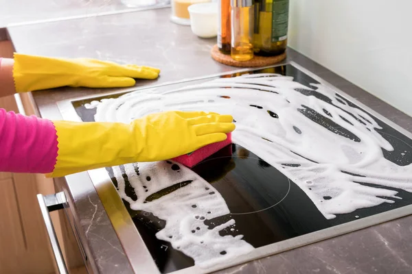 Wanita membersihkan kompor dapur — Stok Foto