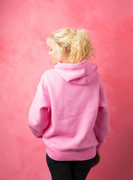 Kvinna i rosa hoodie stående med ryggen vände — Stockfoto