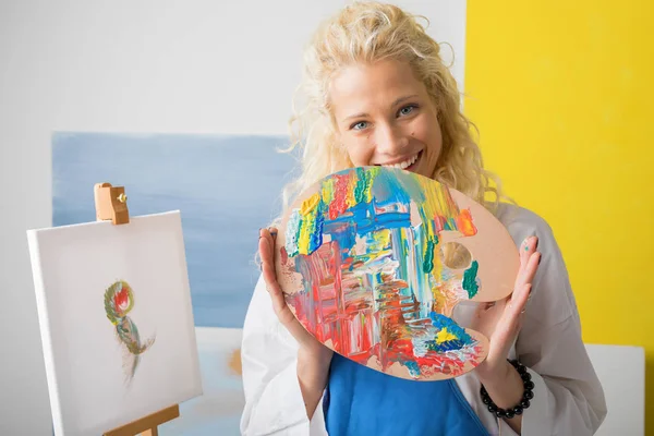 Mulher artista segurando paleta de cores em seu estúdio — Fotografia de Stock