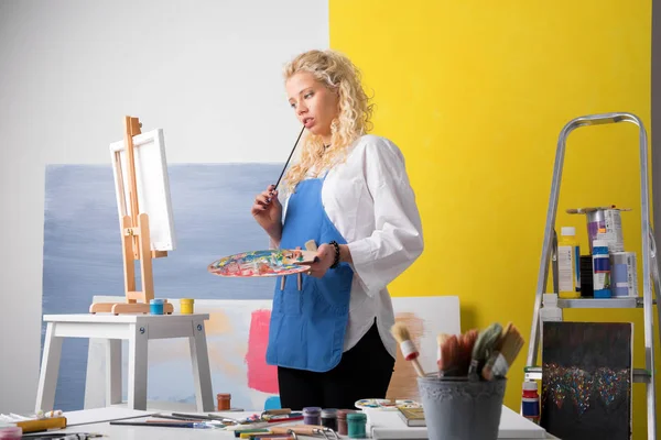 Thoughtful  painter looking at her painting — Stock Photo, Image