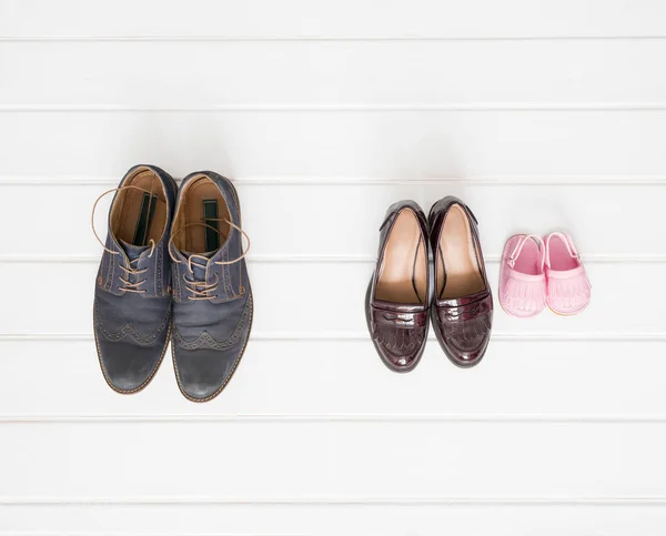 Férfiak, nők és gyermekek cipő telepítő fehér háttér — Stock Fotó