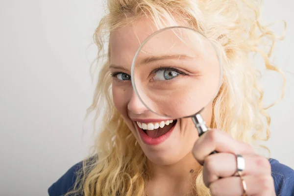 Woman looking through magnifying glass — Stock Photo, Image