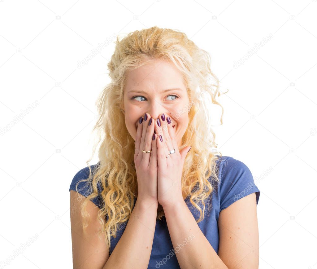 Woman secretly laughing with her mouth covered 