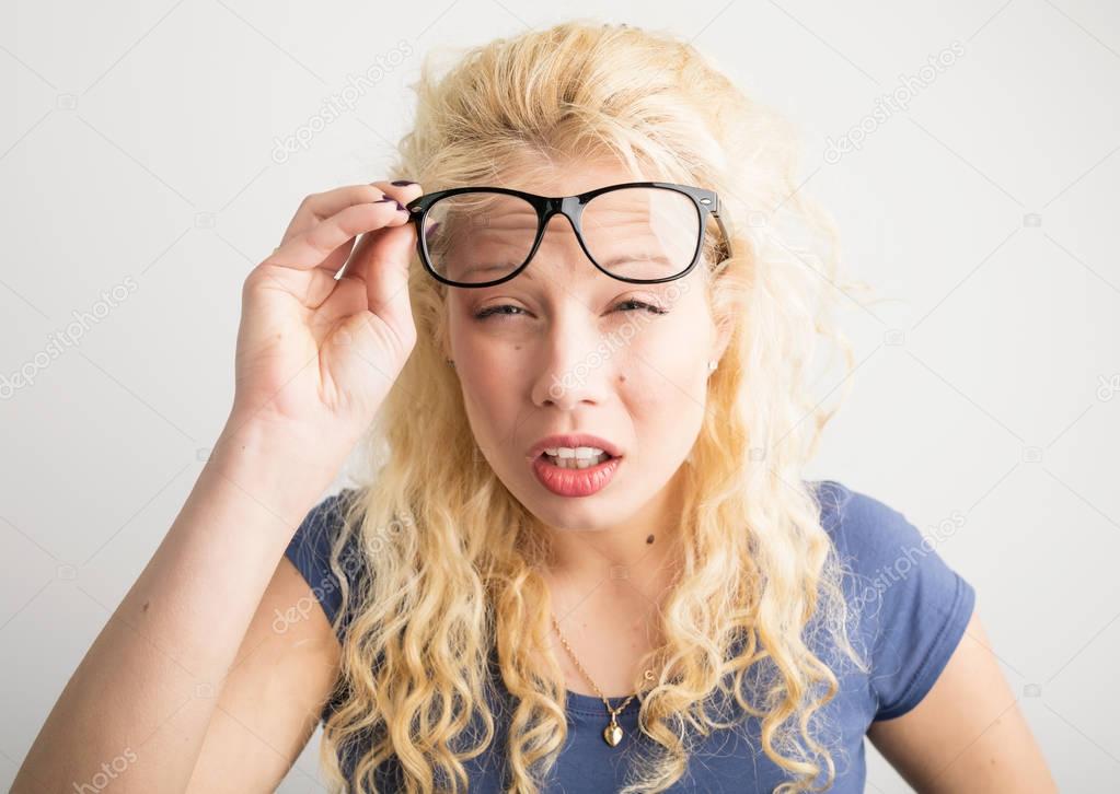Woman with her glasses lifted up can't see