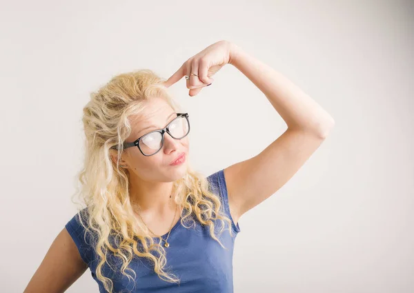 Mujer señalando su dedo a su cabeza — Foto de Stock