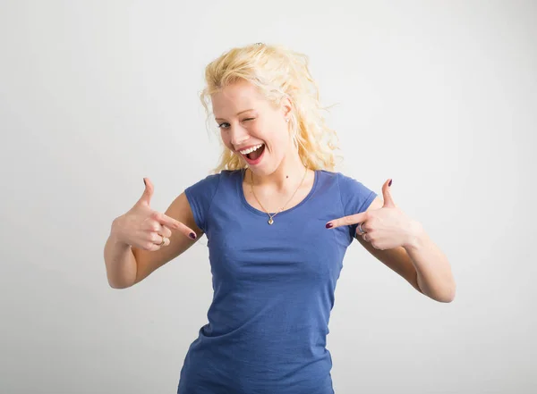 Mulher feliz e engraçada apontando para sua camiseta — Fotografia de Stock