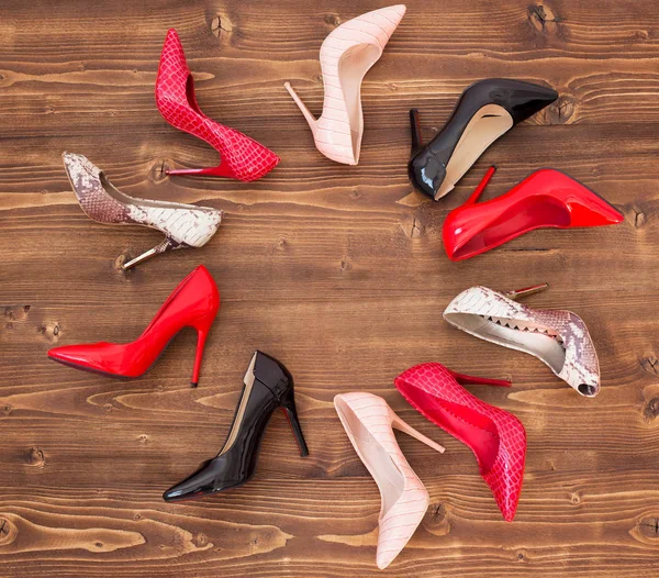 Different high heels on wooden floor — Stock Photo, Image