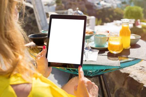 Mulher usando computador tablet enquanto toma café da manhã — Fotografia de Stock