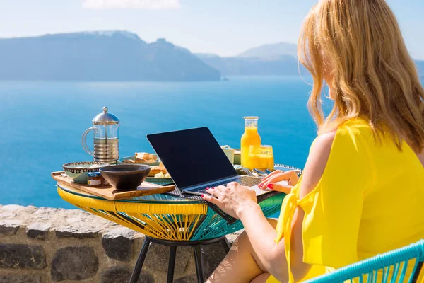 Woman working with laptop computer while having breakfast — Stock Photo, Image