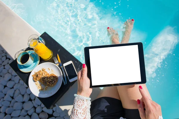 Woman using tablet by the pool — Stock Photo, Image