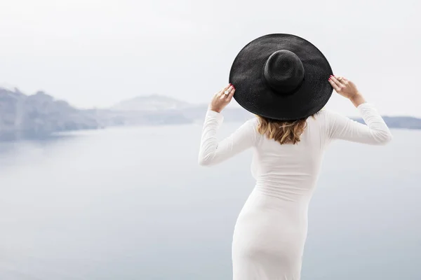 흰 드레스에 검은 모자를 뒤에서 세련 된 여자 — 스톡 사진
