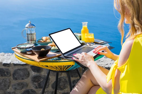 Mujer que trabaja con ordenador portátil mientras desayuna en la terraza — Foto de Stock