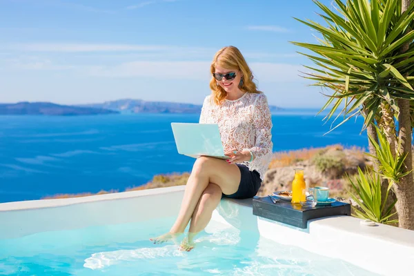 Zakenvrouw op vakantie die op laptop werkt — Stockfoto