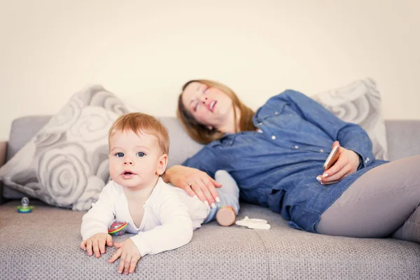 Bebê brincando enquanto a mãe está dormindo — Fotografia de Stock