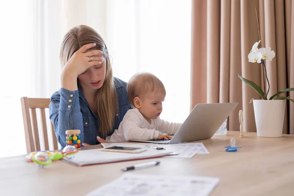 Tired working mom with child in her lap feeling exhausted — Stock Photo, Image