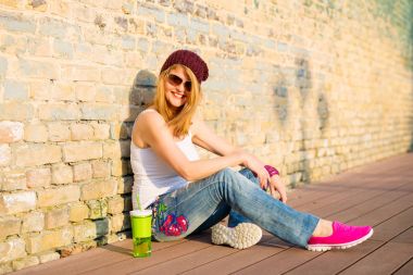 Şapka ve güneş gözlüğü yere oturmuş hipster