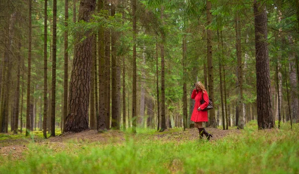 Mujer con abrigo rojo en el bosque — Foto de Stock