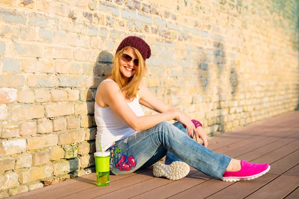 Şapka ve güneş gözlüğü yere oturmuş hipster