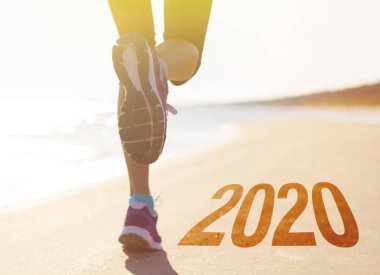 Plajda koşan fitness kadını. Yeni yılda sağlıklı ve aktif kalma kavramı.