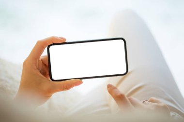 Boş beyaz ekran ile yatay olarak cep telefonu tutan kişi, kendi tasarımınız için akıllı telefonun maket fotoğrafı
