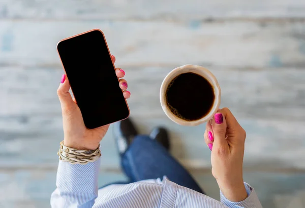 Vrouw Die Mobiele Telefoon Gebruikt Een Kop Koffie Vasthoudt — Stockfoto