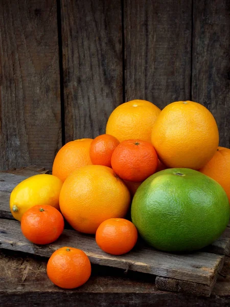 Composition d'agrumes sur fond bois : mandarines, oranges, chou, citron. Vue latérale — Photo