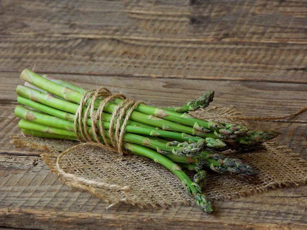 Bund frischer grüner Spargel auf Holzgrund — Stockfoto