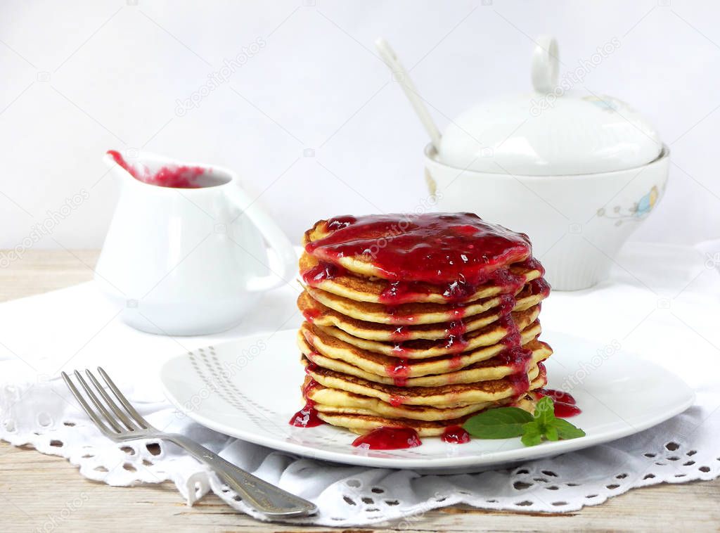 Stack of delicious pancakes with berries and jam on white background. Breakfast. View from side. Selective focus