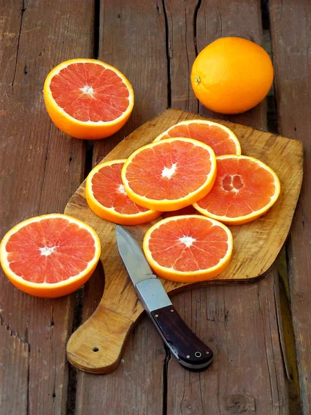 Tranché orange sang sicilien mûr sur une planche à découper en bois. Concentration sélective . — Photo