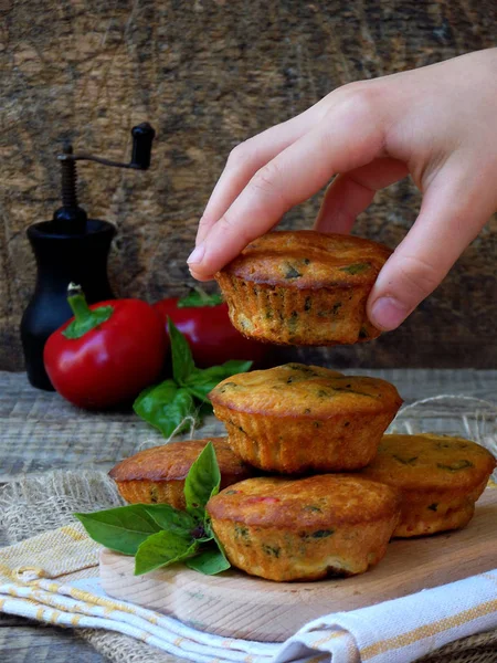 salty snack muffins with feta, pepper and basil on a dark background. selective focus