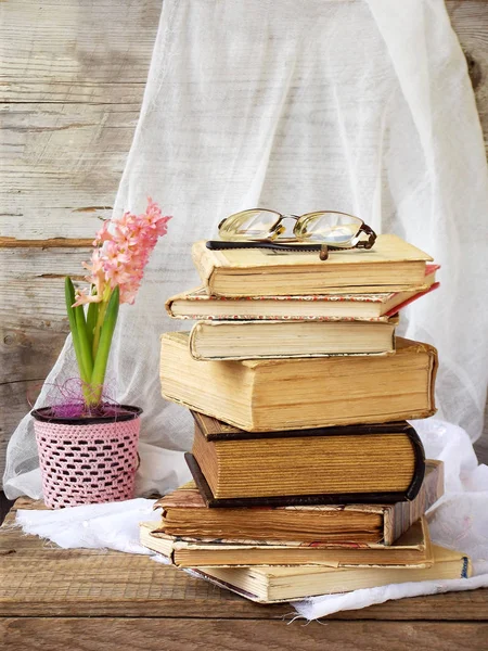 Stos starych książek w twardej oprawie i hiacynt na podłoże drewniane. Selektywny fokus. Miejsce — Zdjęcie stockowe