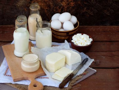 Ahşap arka plan üzerinde taze süt ürünleri kümesi: süt, peynir, yazlık, yoğurt, yumurta, mozzarella peyniri, ryazhenka, beyaz.
