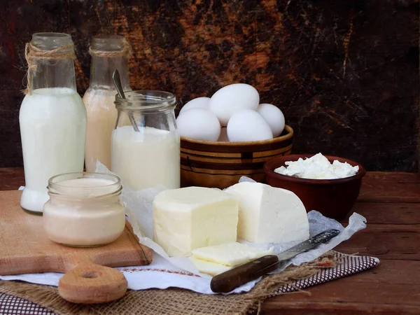 Uppsättning av färska mjölkprodukter på trä bakgrund: mjölk, ost, cottage, yoghurt, ägg, mozzarella, ryazhenka, feta. — Stockfoto