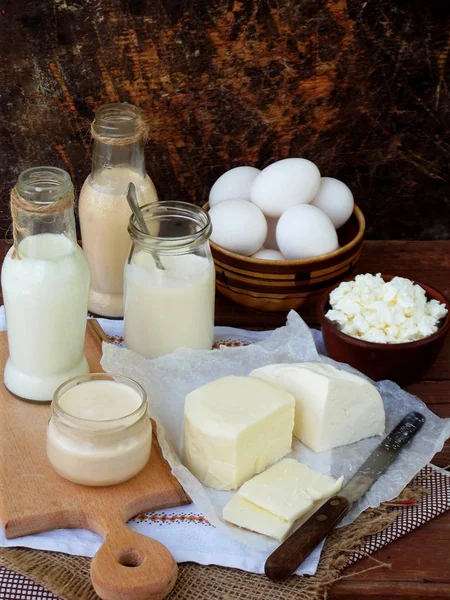 Frische Milchprodukte auf hölzernem Hintergrund: Milch, Käse, Hütte, Joghurt, Ei, Mozzarella, Rjazhenka, Feta. — Stockfoto