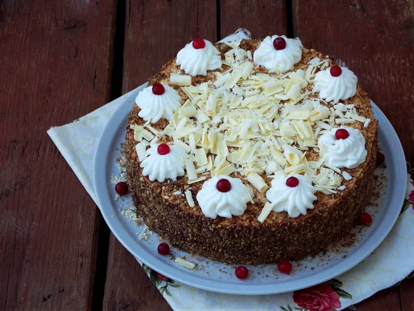 Torta al cioccolato decorata con rosette di crema e bacche su uno sfondo di legno . — Foto Stock