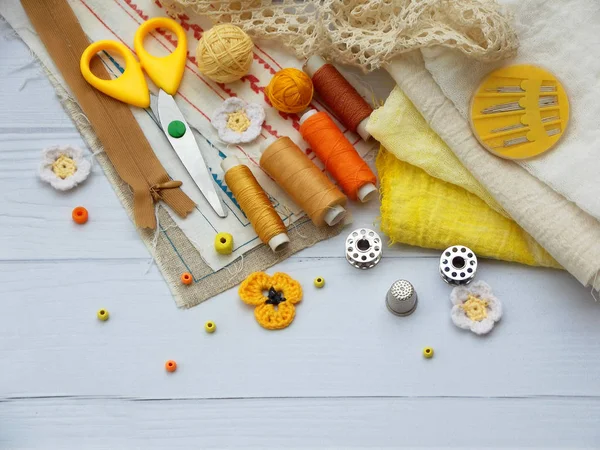 Samenstelling van gele accessoires voor handwerk op houten achtergrond. Breien, borduren, naaien. Kleine bedrijven. Inkomsten uit hobby. — Stockfoto