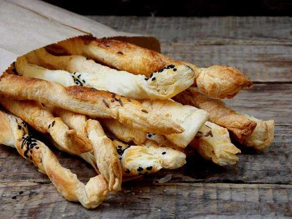 Puf böreği tuzlu sopa ahşap bir arka plan üzerinde kimyon ve çörek otu serpilir — Stok fotoğraf