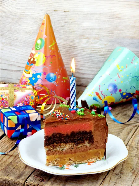 piece of cake Fairy Tale and a candle - nut biscuit, caramel, crumble with chocolate, currant cream and chocolate mousse. Happy Birthday. selective focus. copy space