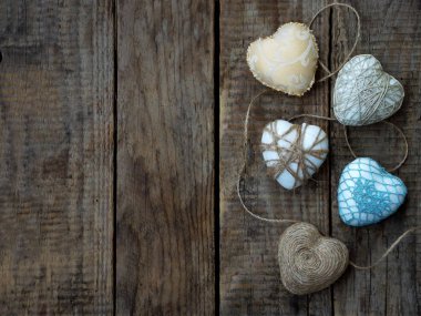 Sevgililer günü kavramı. Ahşap arka plan üzerinde renkli el yapımı kalplerin kompozisyon. İğne işi. Uzay kopyalayın. Seçici odak