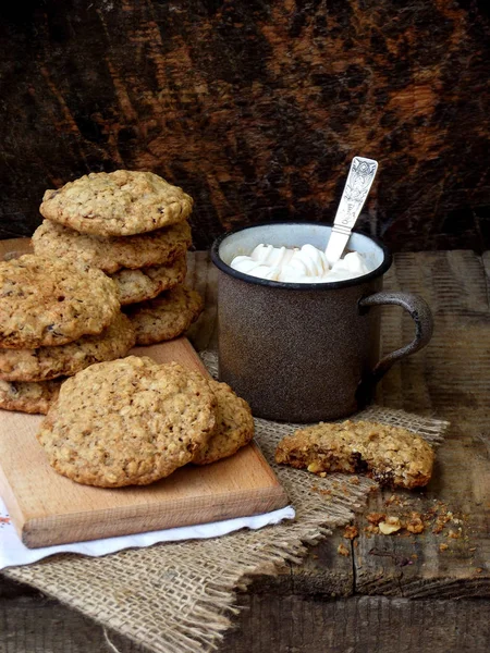 Mehllose glutenfreie Erdnussbutter, Haferflocken, Trockenobst-Kekse und eine Tasse Kakao mit Marshmallows auf Holzuntergrund. Vertikal. Kopierraum — Stockfoto
