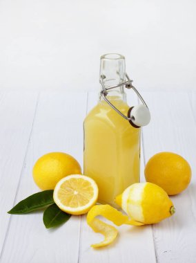Taze sıkılmış limon suyu şişesi ve limon açık renkli. Vitamin içeceği veya kokteyl için. Seçici odak. Metin için yer