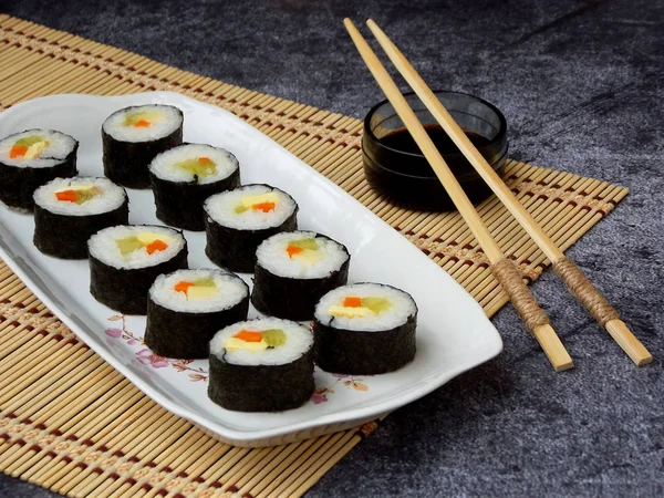 Sushi auf weißem Teller, grauer Hintergrund. traditionelle asiatische Küche. Ernährung gesunde Ernährung. Selektiver Fokus. Raum für Text — Stockfoto