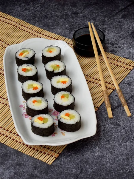 Sushi di piring putih, latar belakang abu-abu. Makanan tradisional Asia. Diet makanan sehat. Fokus selektif. Ruang untuk teks — Stok Foto