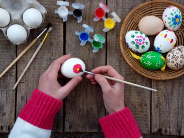 Kız çiçek desenleri guaj boya yumurta eller. Yumurta dekorasyon. Paskalya için hazırlık.