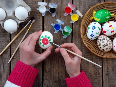 Kız çiçek desenleri guaj boya yumurta eller. Yumurta dekorasyon. Paskalya için hazırlık.